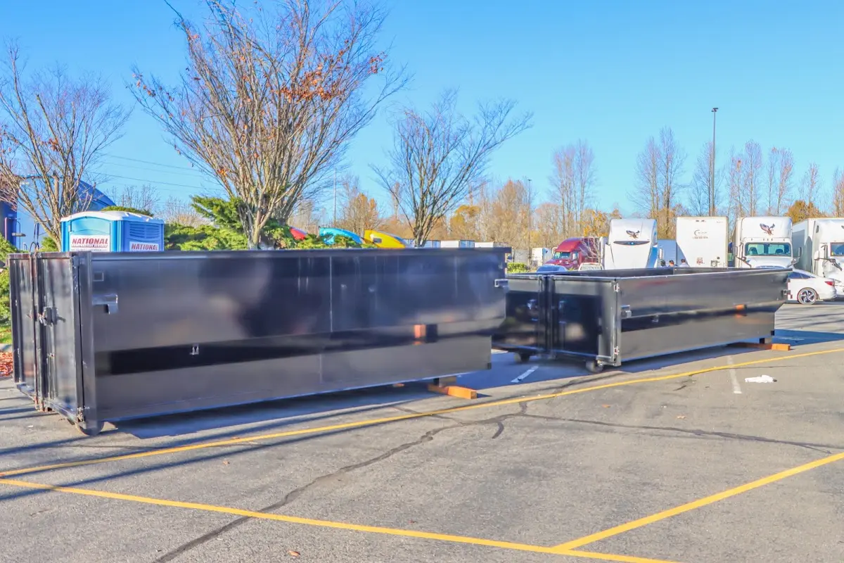 Professional dumpster rental service with roll-off container on residential driveway in Upper Milford